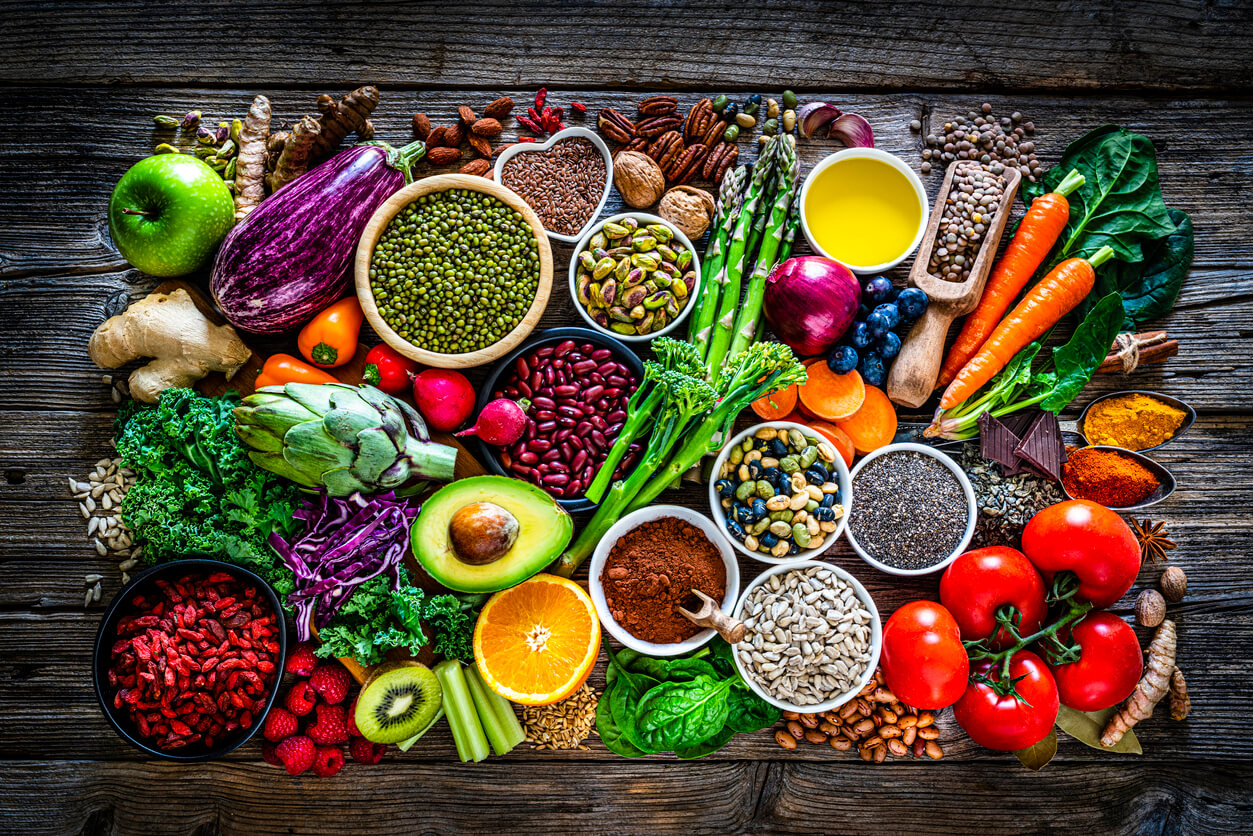 Vitamin rich fruits, vegetables, and seeds spread on a table.