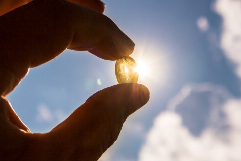 Vitamin D capsule held up to the sun