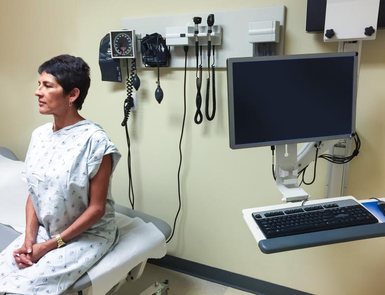 Woman sitting in a hospital examination room Woman sitting in a hospital examination room