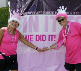 Couple holding hands in front of cancer awareness sign Couple holding hands in front of cancer awareness sign