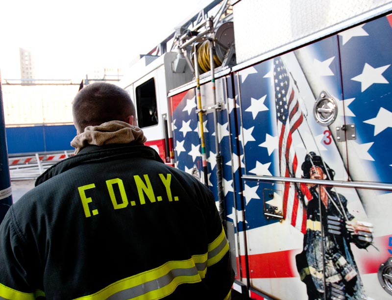 FDNY firefighter looking at 9/11 memorial on fire truck FDNY firefighter looking at 9/11 memorial on fire truck