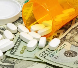 Bottle of pills spilling on money Bottle of pills spilling on money