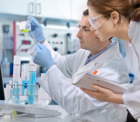 Researchers looking at test tubes Researchers looking at test tubes