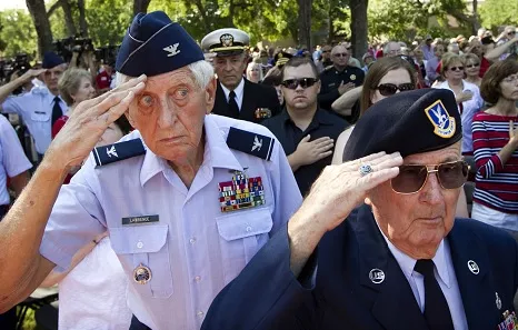 Two U.S. Air Force veterans saluting in a crowd