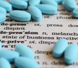 Blue antidepressant pills on a dictionary Blue antidepressant pills on a dictionary