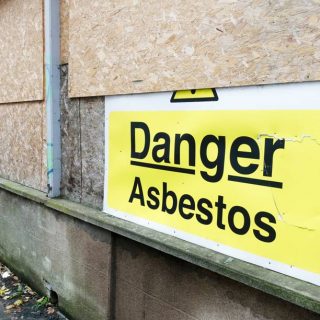 Asbestos warning on boarded up building