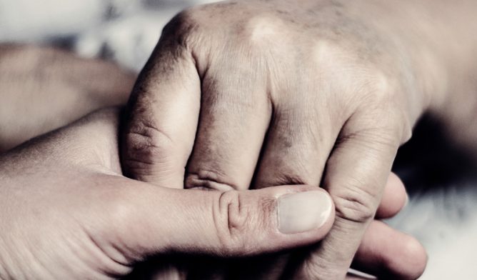 Caregiver holding hand of patient