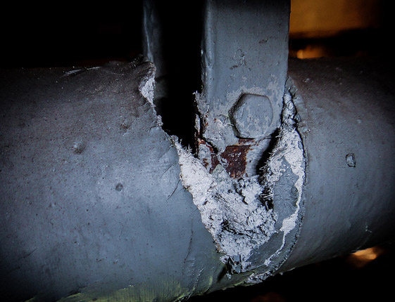 Section of exposed asbestos pipe insulation Section of exposed asbestos pipe insulation