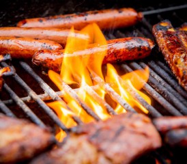 Meats and hot dogs grilling over an open flame. Meats and hot dogs grilling over an open flame.