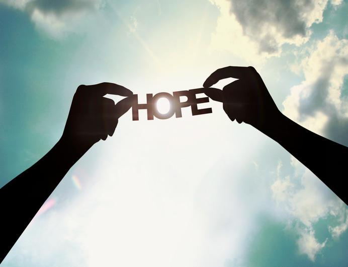 Hands holding paper cut of hope Hands holding paper cut of hope