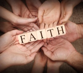 Hands holding block letters that spell faith