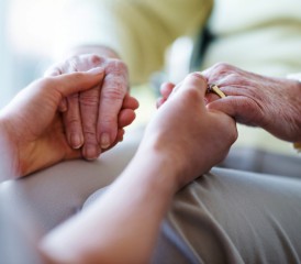 A person holding another person's hands in a consoling manner A person holding another person's hands in a consoling manner
