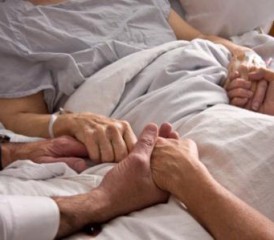 Holding Hands of a Loved One in a Hospital Bed Holding Hands of a Loved One in a Hospital Bed