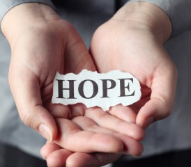 Hands holding paper with hope written on it. Hands holding paper with hope written on it.