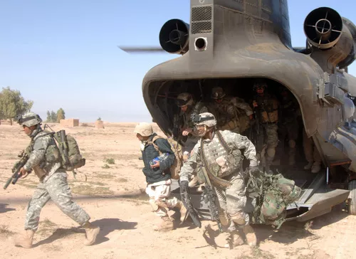 U.S. Soldiers running out of a CH-47 Chinook helicopter during the Iraq war.
