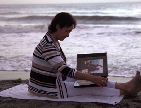 Lorraine Kember on the beach with photo album Lorraine Kember on the beach with photo album