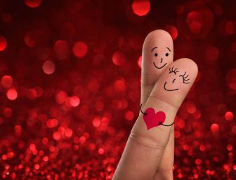 Fingers painted with happy faces in love