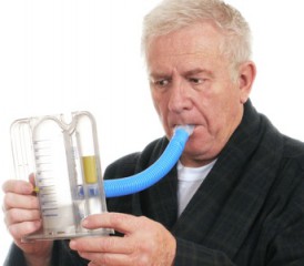 Man breathing into a lung exerciser Man breathing into a lung exerciser
