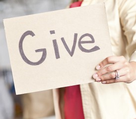 Woman holding sign for giving donations Woman holding sign for giving donations