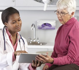 Doctor showing patient information on iPad Doctor showing patient information on iPad