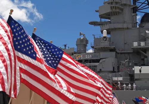 American flags in front of a U.S. Navy ship.