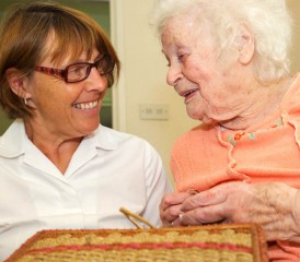 Nurse comforting an elderly woman with needlework Nurse comforting an elderly woman with needlework