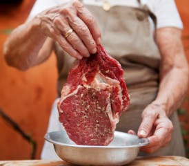 Man seasoning a piece of steak Man seasoning a piece of steak