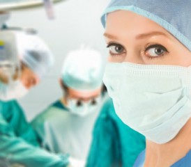 Female surgeon wearing mask in an operating room Female surgeon wearing mask in an operating room