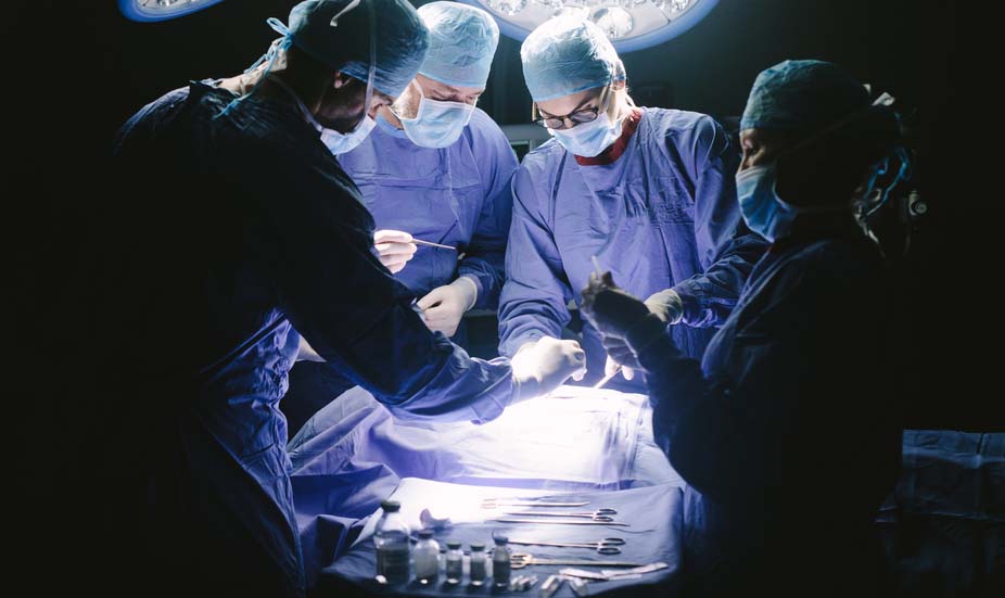 Surgeons performing surgical procedure in operating theatre Surgeons performing surgical procedure in operating theatre