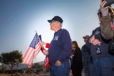 Military veteran holding a U.S. flag with family