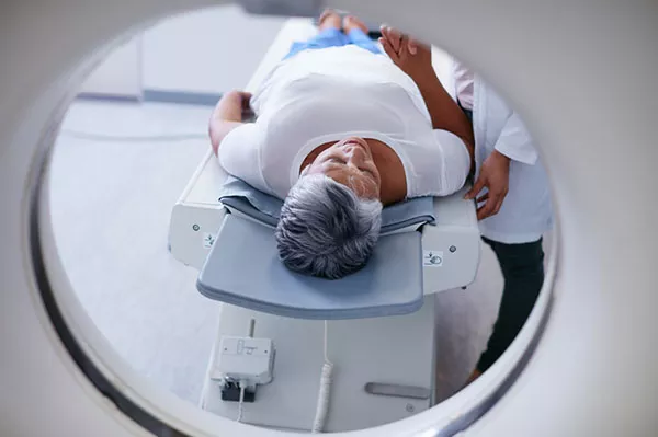 An older woman undergoing a CT-PET scan, a common tool in mesothelioma testing.