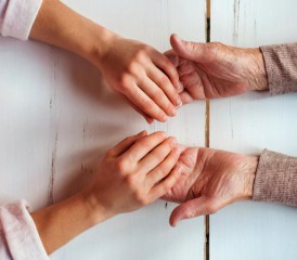 Two women holding hands over a table Two women holding hands over a table